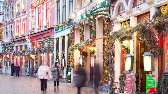 Blick auf eine weihnachtlich geschmückte Straße mit Läden und Restaurants in Brügge, Belgien. © Loop Images/Universal Images Group via Getty Images