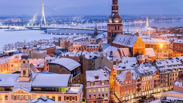 Rigaer Kathedrale (Mitte rechts), Riga, Lettland Vanšu-Brücke (links) Foto zur Weihnachtszeit bei Nacht aufgenommen, Lettland. © joe daniel price via Getty Images