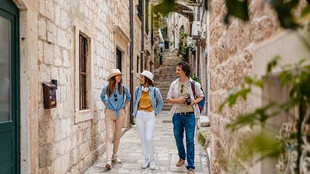 Drei Personen laufen durch eine Gasse in Dubrovnik, Kroatien.