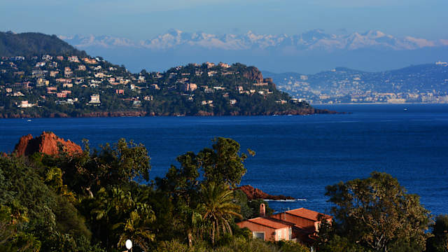 Blick auf die Küste der französischen Riviera mit den verschneiten Alpen im Hintergrund. © ICHAUVEL via Getty Images