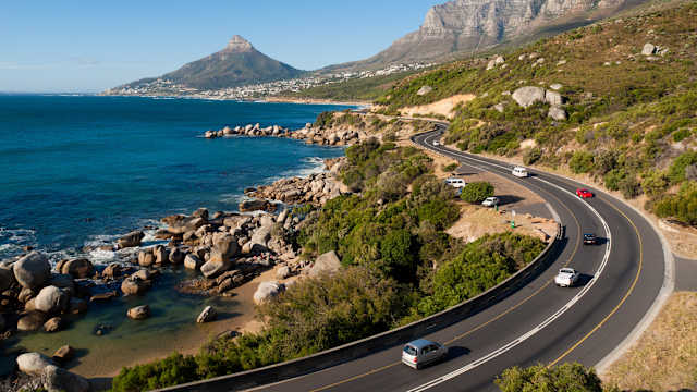 Garden Route - die Straße von Kapstadt entlang der südafrikanischen Küste. Hier ist das Ende der Gartenroute abgebildet, die an den Zwölf Aposteln, Lions Head vorbei und in Richtung Tafelberg führt, Südafrika. © holgs via Getty Images