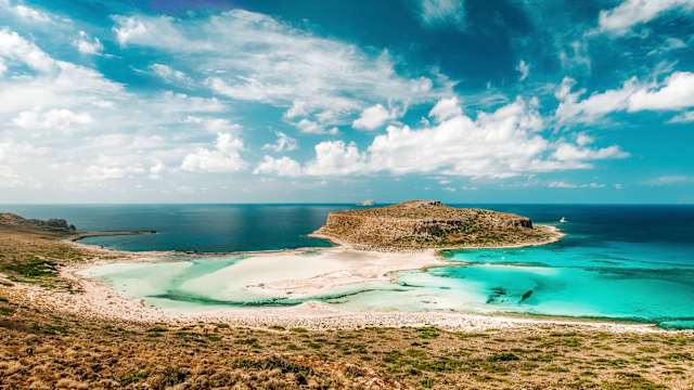 Eine Insel umhüllt von türkisblauem Meer.