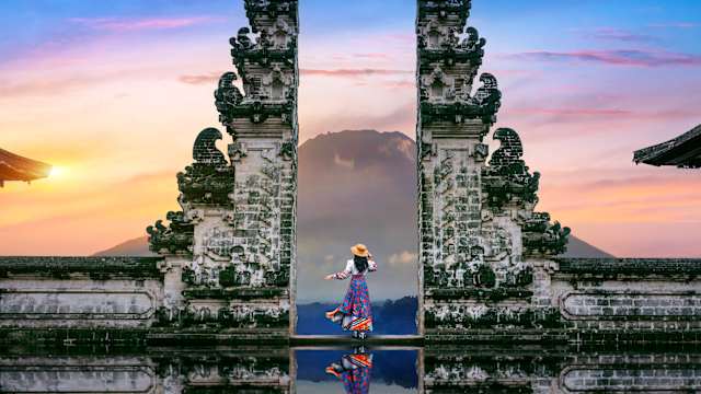 Junge Frau steht in Tempeltoren des Lempuyang Luhur Tempels auf Bali, Indonesien. © tawatchaiprakobkit via Getty Images