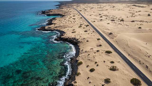 Küstenautobahn von oben mit Sanddünen, Corralejo, Fuerteventura, Spanien. © Mlenny via Getty Images