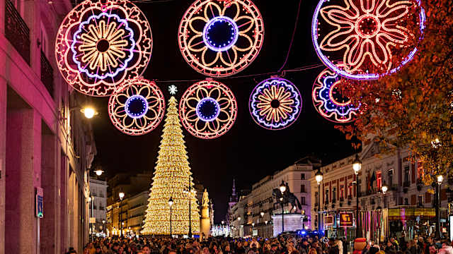 Viele Menschen laufen durch die weihnachtlich geschmückten Straßen Madrids. © Miguel Candela/SOPA Images/LightRocket via Getty Images