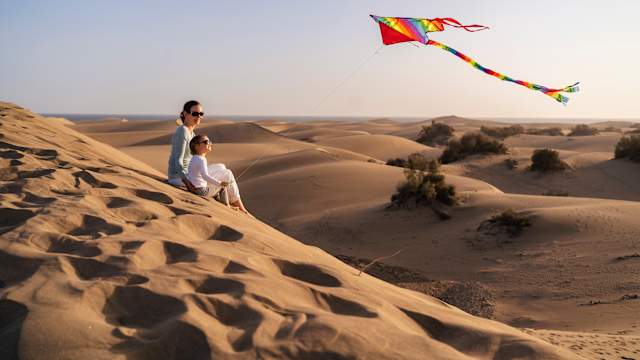 Mutter und Tochter lassen einen Drachen steigen in den Sanddünen, Gran Canaria, Spanien. © Westend61 via Getty Images