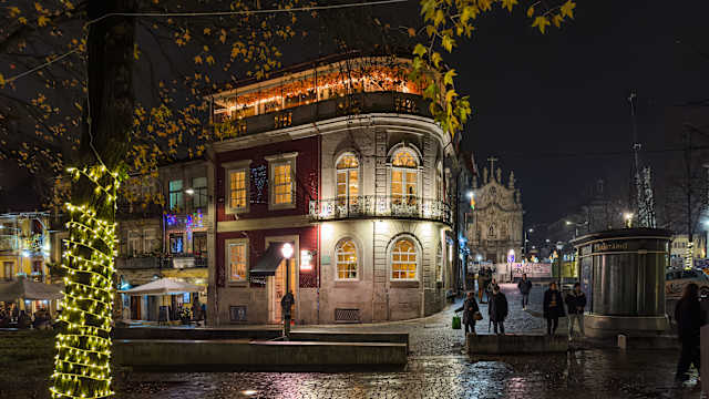 Anwohner und Besucher spazieren durch die Straßen, um die Weihnachtsbeleuchtung und den mit Lichtern geschmückten Musikpavillon des Cordoaria-Gartens zu sehen, Porto, Portugal. © AnaMOMarques via Getty Images