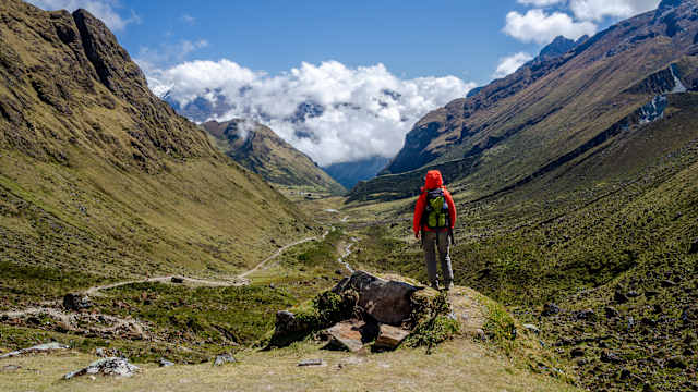 Eine Person in Wanderklamotten in den Bergen