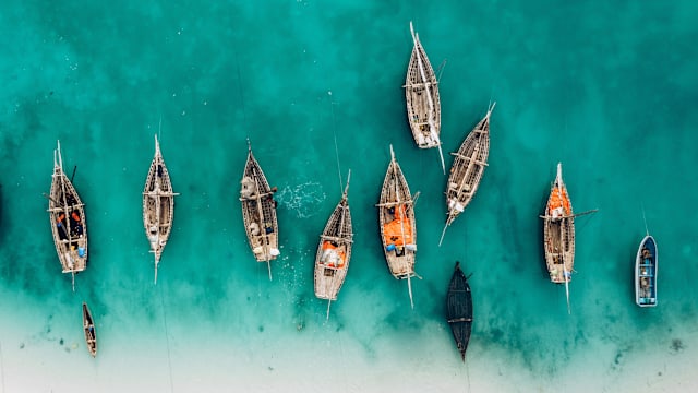 Vogelperspektive auf hölzerne Fischerboote an einem Strand.