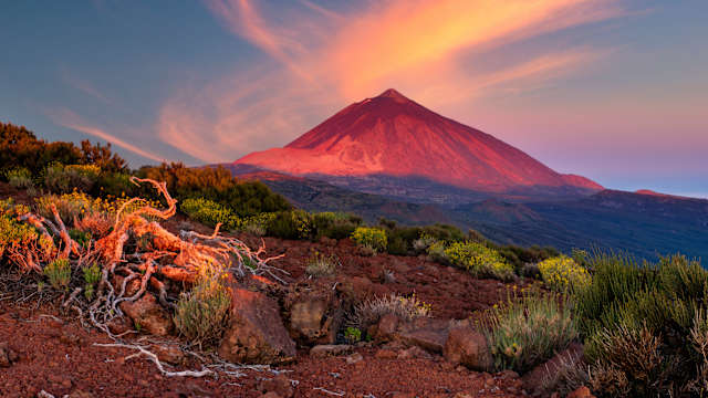Ein Berg wird von der untergehenden Sonne beschienen.