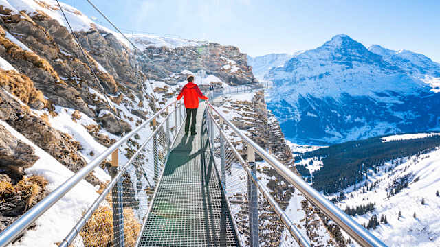 Ein Mann auf einem Wanderweg in den Bergen von Grindelwald, Schweiz.