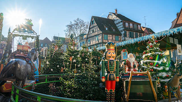 Weitwinkelansicht von bunten elsässischen Häusern und Geschäften am Kanal in Colmar. © wilatlak villette via Getty Images
