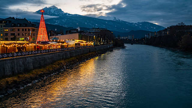 Weihnachtsmarkt am Inn in Innsbruck in der Dämmerung, Österreich. © Cavan Images / Henn Photography via Getty Images