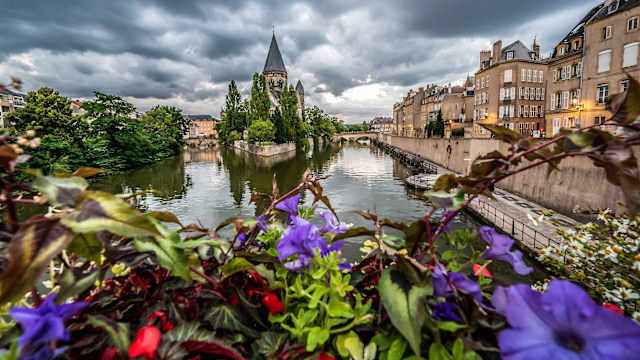 Blick über Blumen auf einen Fluss in Metz