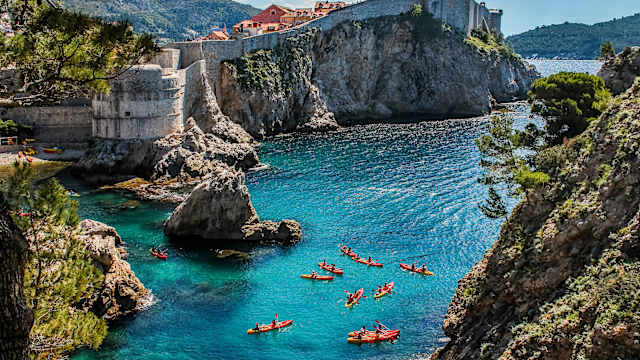 Eine Bucht mit türkisem Wasser und einer Gruppe KanufahrerInnen