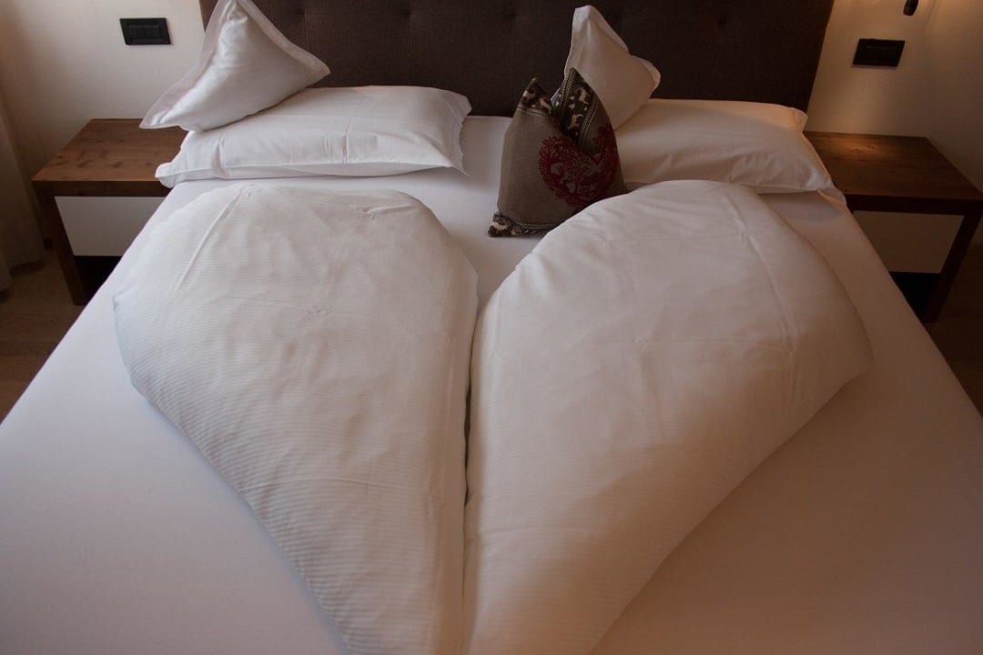 Bett im Schlafzimmer Ariston Dolomiti Residence