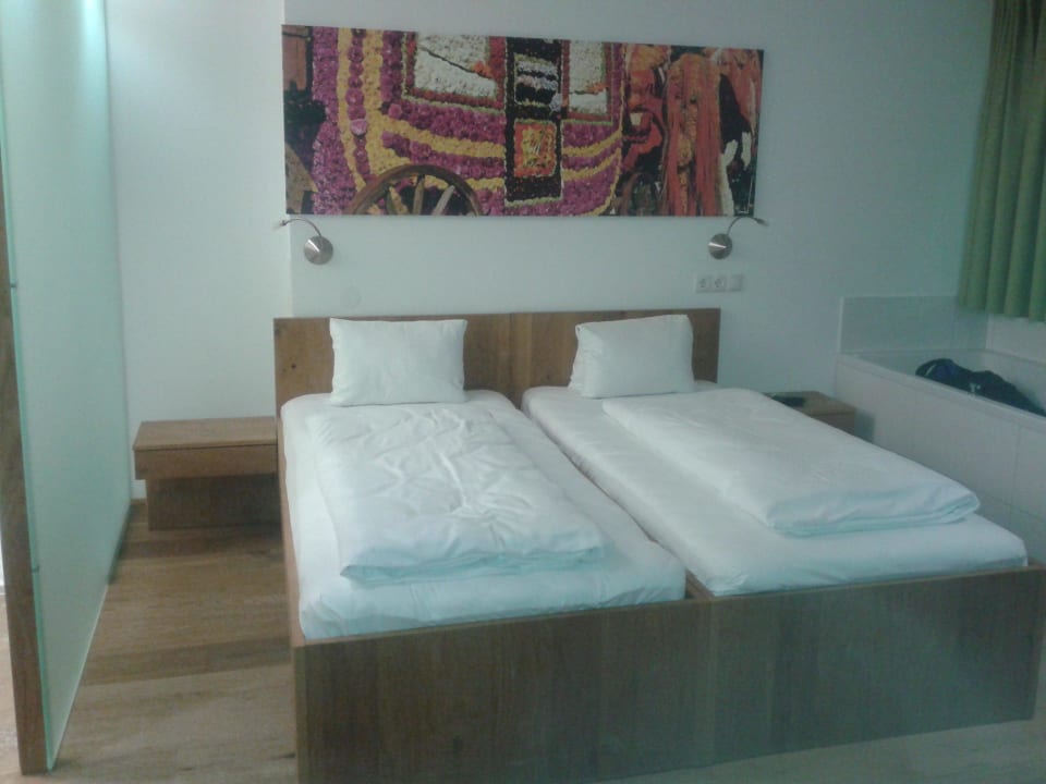 Doppelbett und Badewanne in einem Zimmer Hotel Sattlerwirt