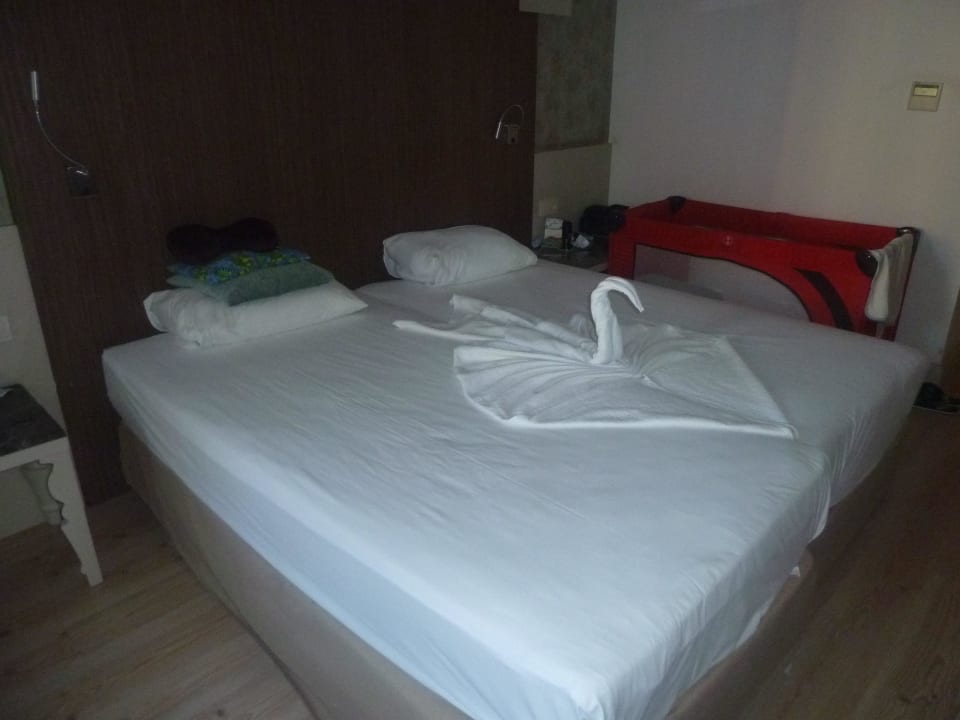 Doppelbett mit einem Handtuchschwan und Baby Bett Port Side Resort Hotel