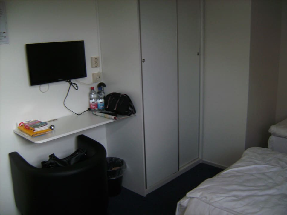Schrank, links Schreibablage & Sessel, darüber TV Hotel De Oude Smidse