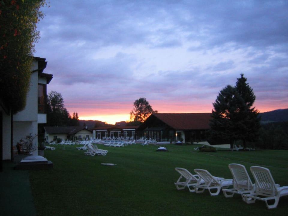 Liegewiese und Schwimmbad mit Sonnenuntergang Riederin Hotel & Chalets