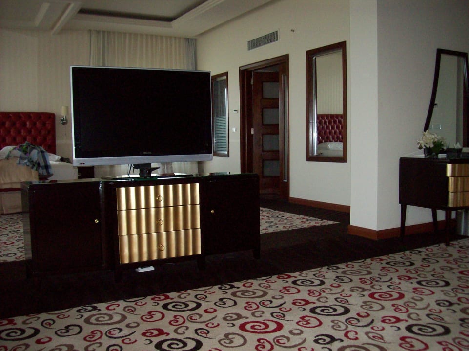 Hinter dem TV-Gerät der Schlafbereich Premier Le Reve Hotel & Spa