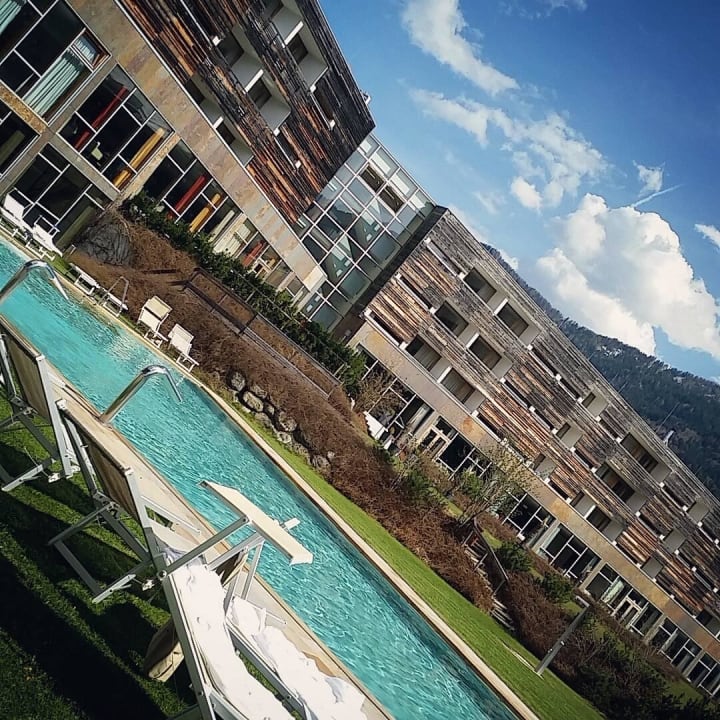 Schöner Außenswimmingpool mit Hotelaußenansicht  Falkensteiner Hotel & Spa Carinzia