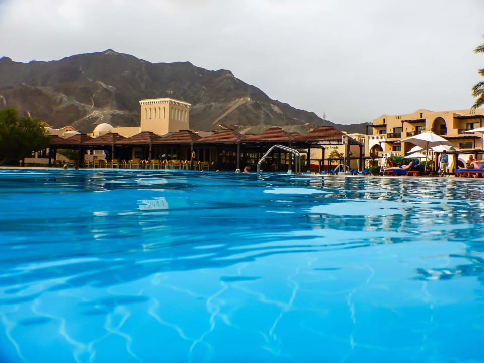 Pool mit Hajar-Gebirge im Hintergrund Miramar Al Aqah Beach Resort