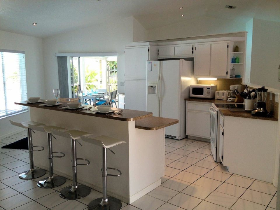 Kuechentheke mit 4 weisse Leder/Barstuehle Loft-Stil Villa The Illoura