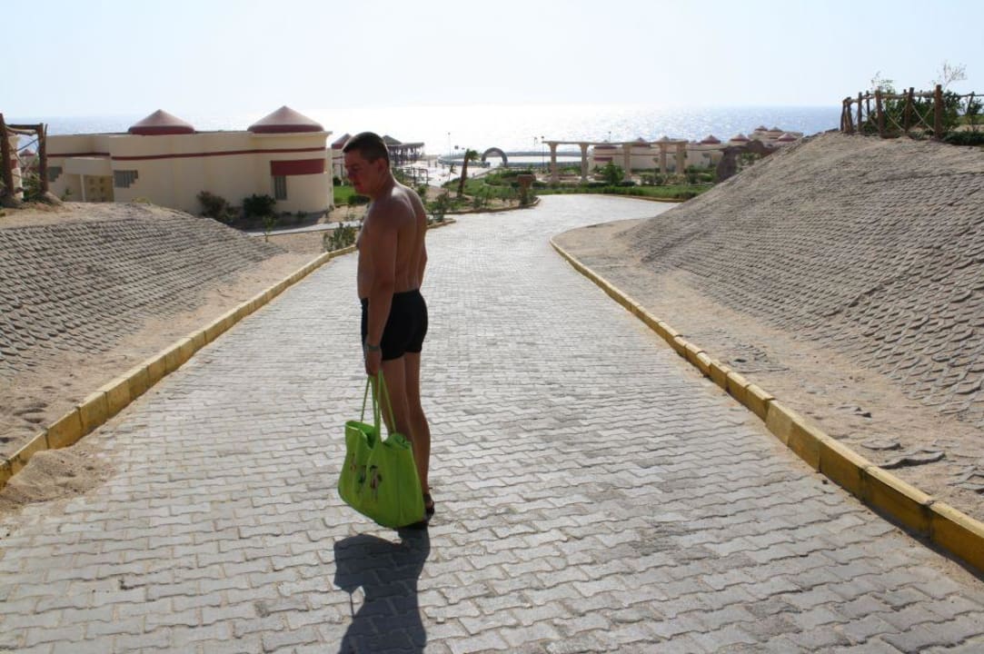 Zejście na plażę kamienistą, w oddali bungalowy Siva Golden Bay Makadi