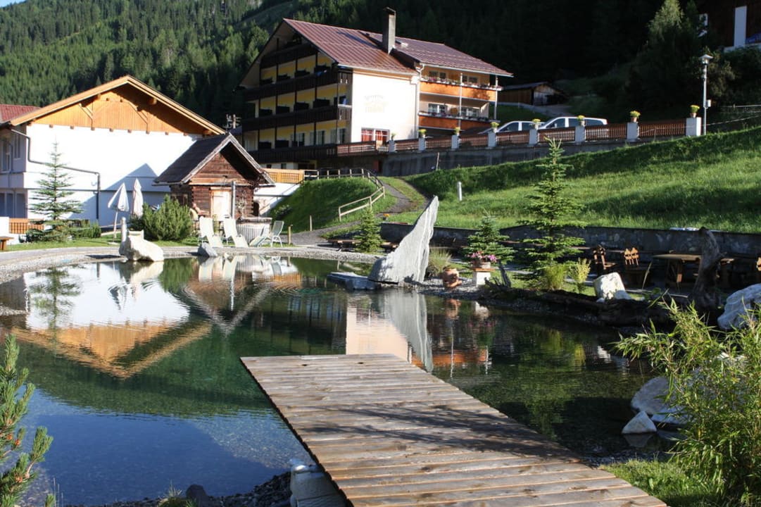 Badeteich mit Blick  auf einen Teil des Hotels Alm-Resort Frühauf