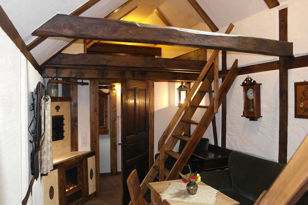 Wohnraum mit Holztreppe zum Hochbett Apartment Altes Hinterhäusel