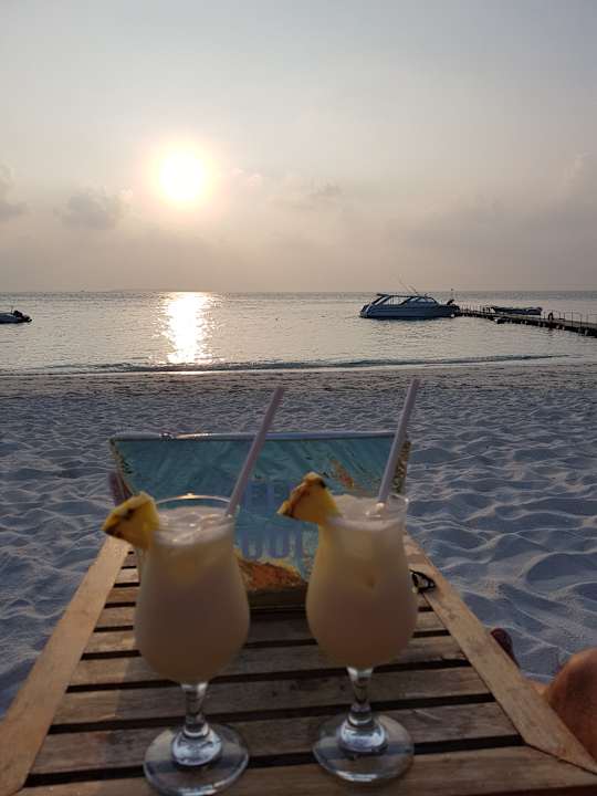 Pina colada inkl. Sonnenuntergang an der Sunset Bar NH Collection Maldives Reethi Resort