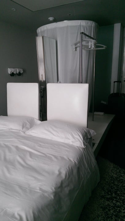 Bett, dahinter Waschbecken und Dusche Hotel Radisson Blu Rome