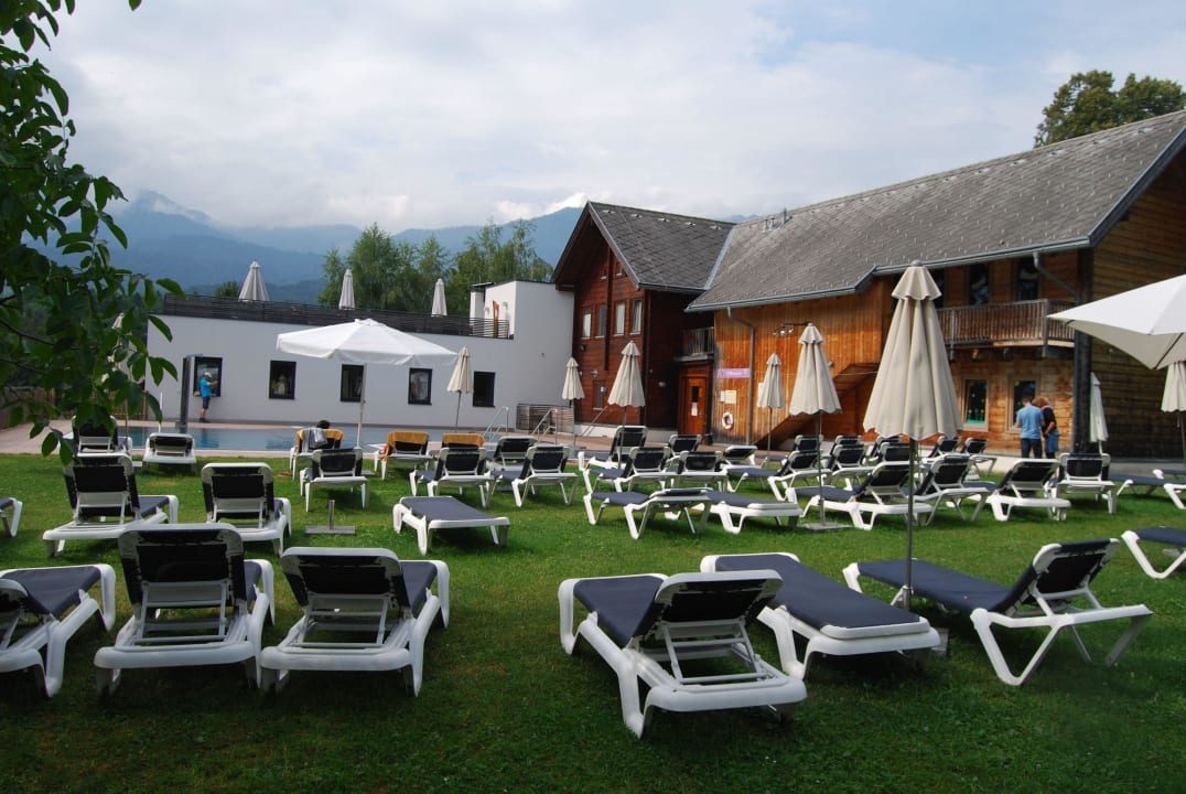 Pool mit Liegestühlen und (rechts) Kindergarten Naturel Hoteldorf Schönleitn