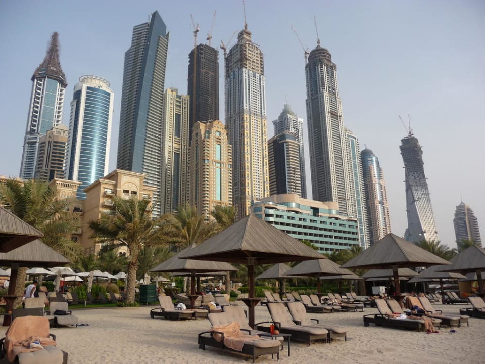 Strand, Hotel und Skyline im Hintergrund Le Meridien Mina Seyahi Beach Resort & Waterpark