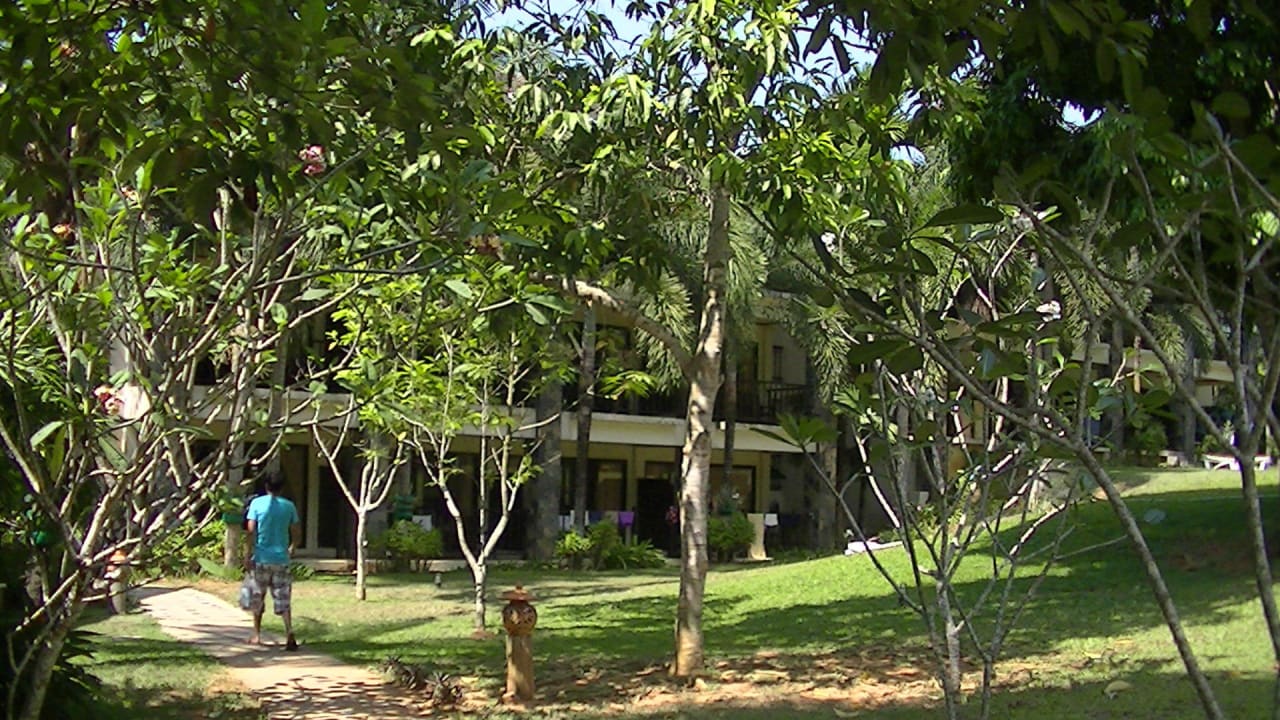 Gartenanlage mit Blick auf einen Hotelteil The Leaf on The Sands by Katathani