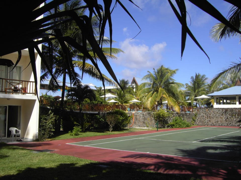 Tennisplatz mit Hotelanlage  Le Peninsula Bay Beach Resort & Spa