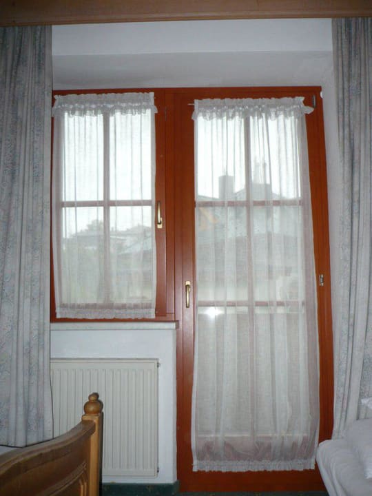 Pohled na okno a dveře vedoucí na balkon Hotel-Gasthof-Obermair