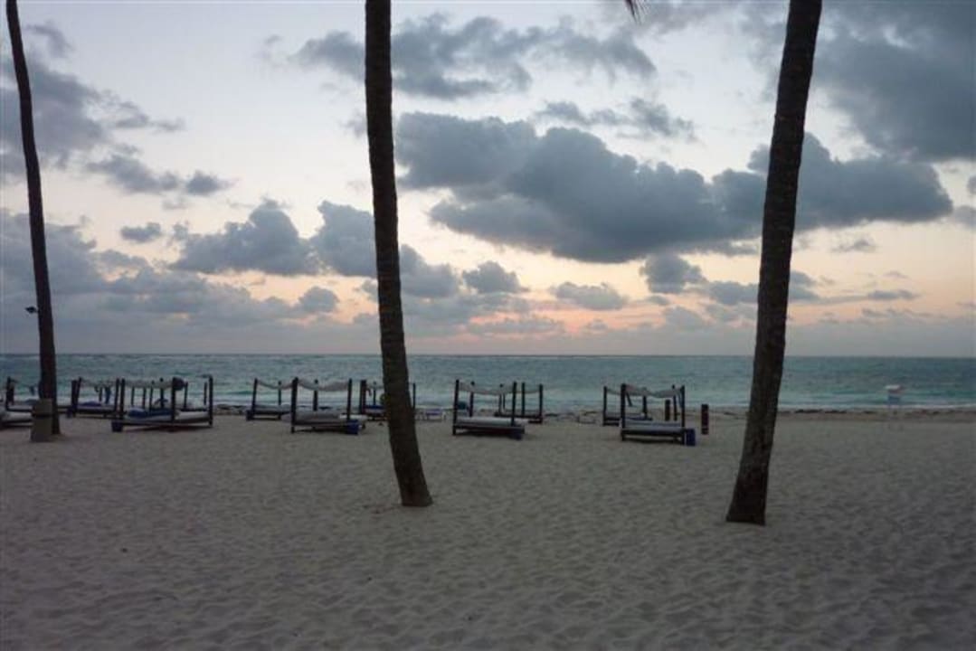 Sonnenaufgang im Hintergrund die Strandliegen Punta Cana Princess All Suites Resort & Spa