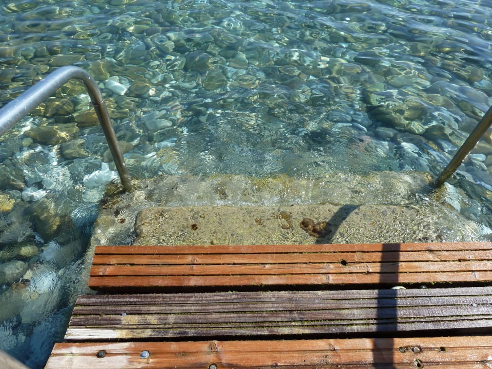 Holzsteg mit steinigem Zugang ins Meer Hydramis Palace Beach Resort