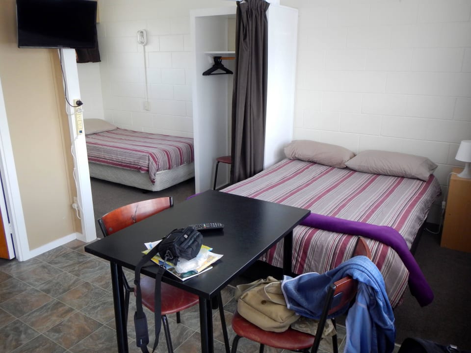 Blick aufs Bett und Nebenzimmer Apartments Whangarei Central Holiday Park