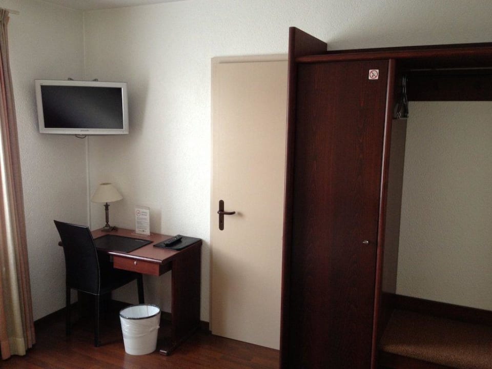 TV und Schreibtisch, daneben Tür zum Bad Hotel Jardin Bern