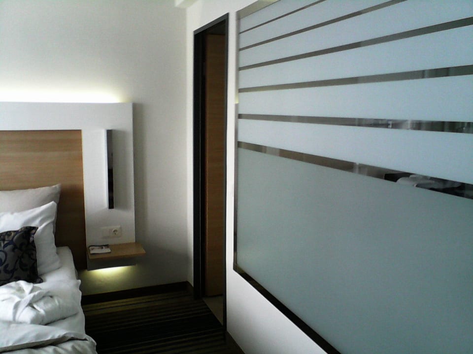 Links Bett, rechts Bad mit großem Glasfenster Best Western Plus Welcome Hotel Frankfurt