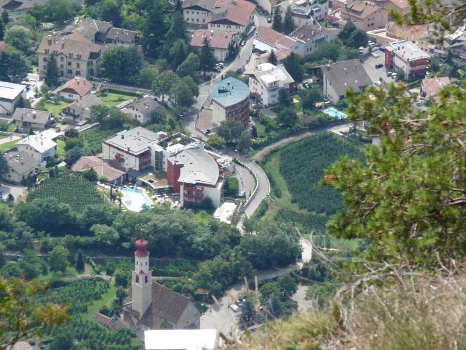 Rotes Hotelgebäude mit Garten und Pool Lindenhof Pure Luxury & Spa DolceVita Resort