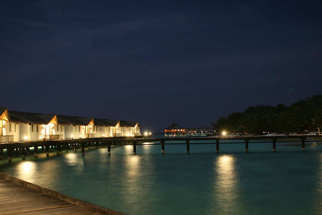 Waterbungalows in der  Nacht NH Collection Maldives Reethi Resort