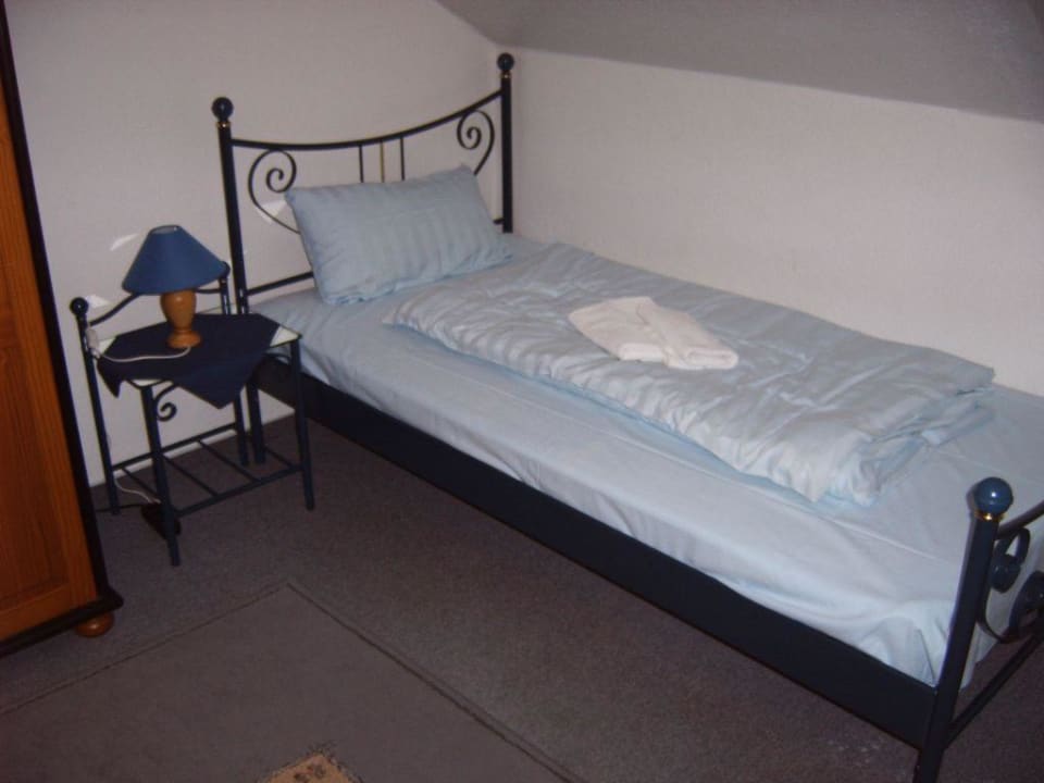 Bett im Schlafzimmer im Obergeschoss Aparthotel Am Schloßpark