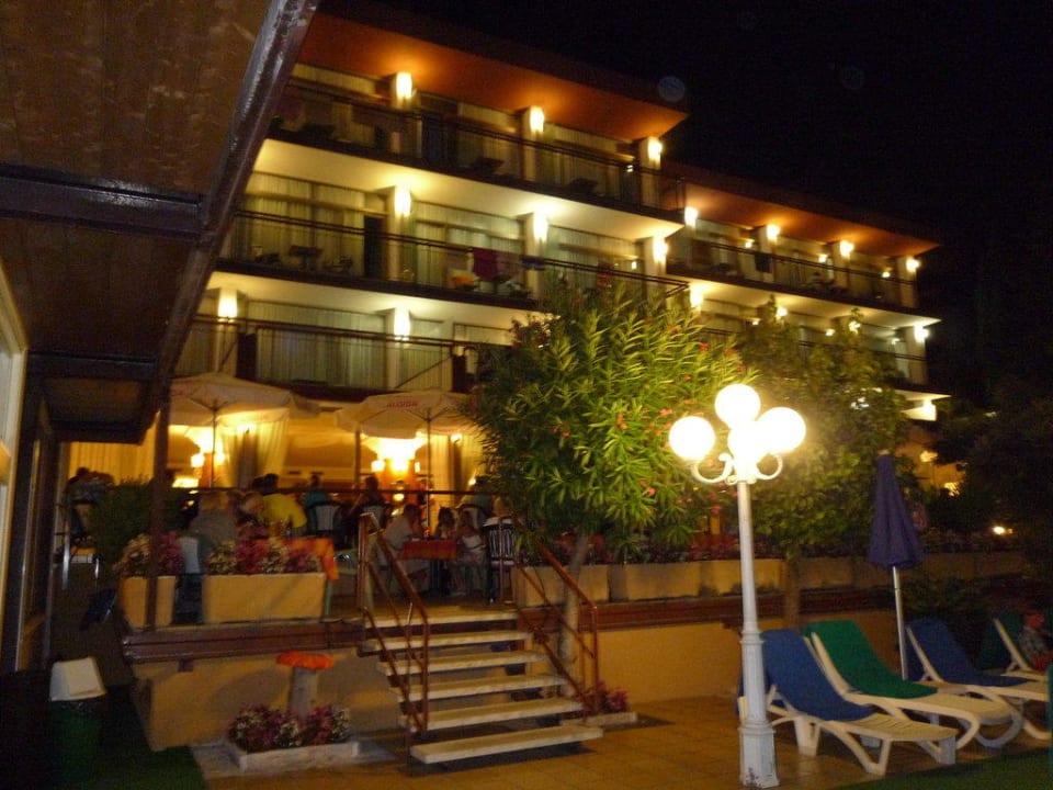 Das ältere Hauptgebäude mit Terrasse bei Nacht Hotel Majestic Palace