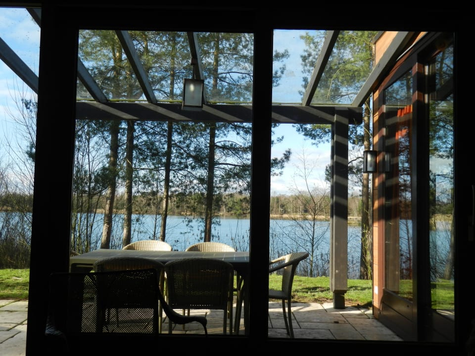 Der Blick auf die Veranda und den See vom Wohnzimmer Center Parcs De Kempervennen