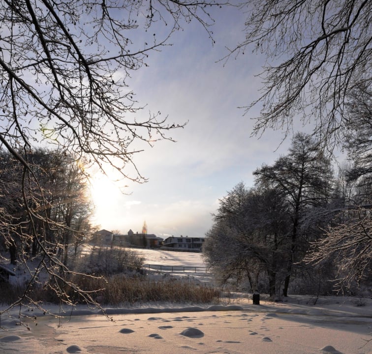 Blick vom winterlichen Weiher zum Hotel Hotel Heinz