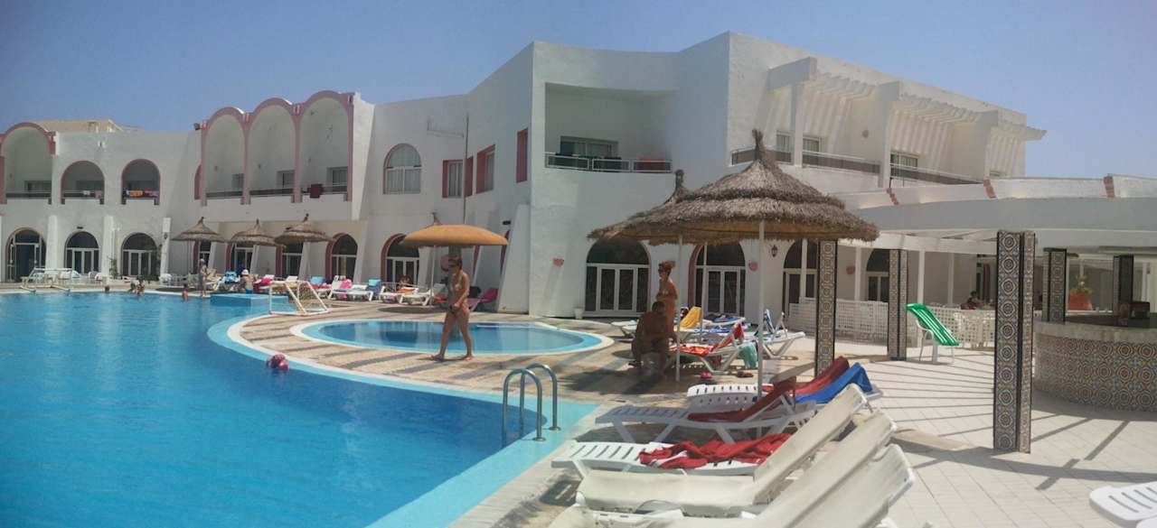 Widok basenu i hotelu Hotel Homère Djerba